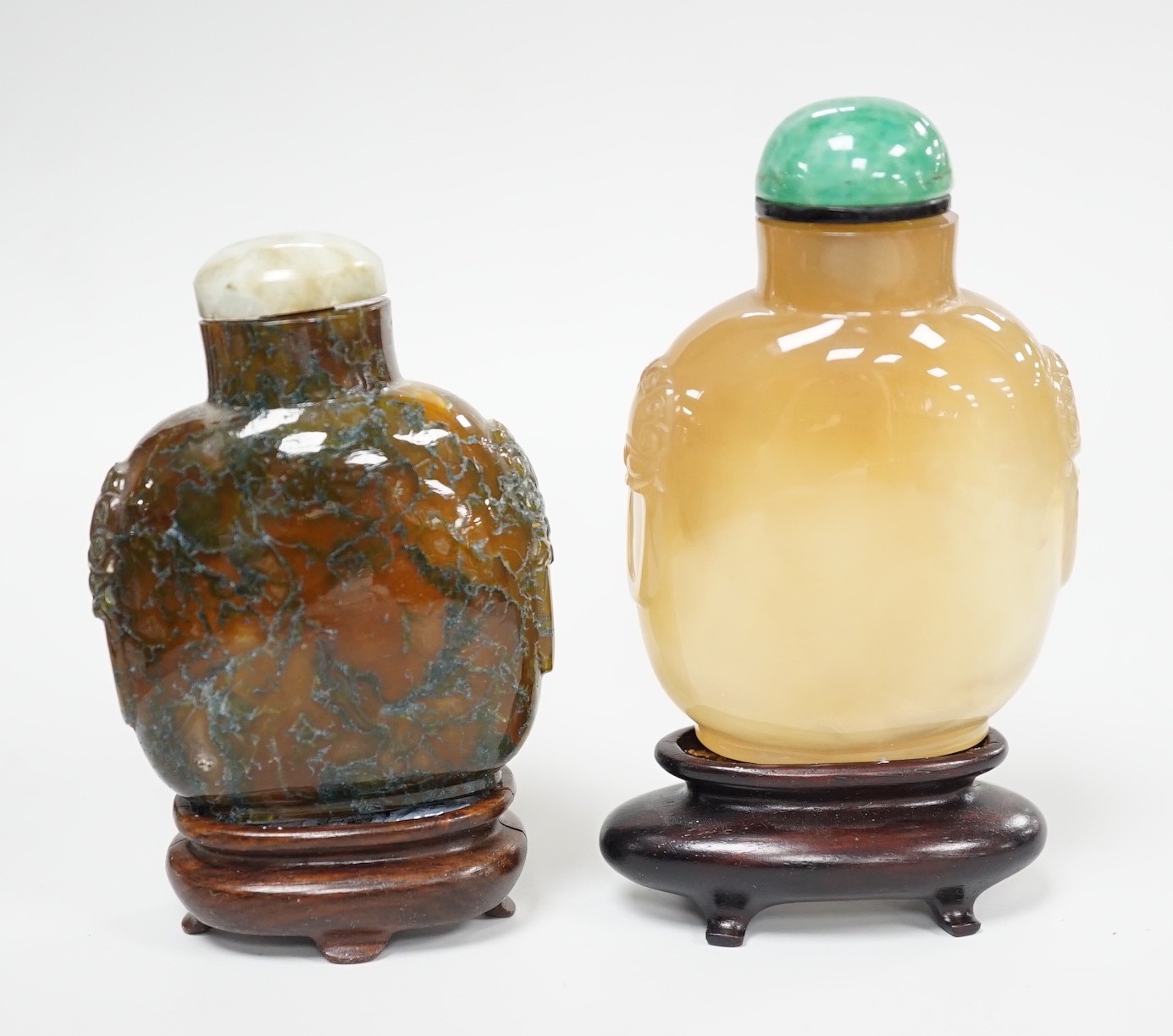 A Chinese honey coloured agate mask and ring handled snuff bottle and a dendritic chalcedony (moss agate) mask and ring handled snuff bottle, 5.7cm, both 1780-1880